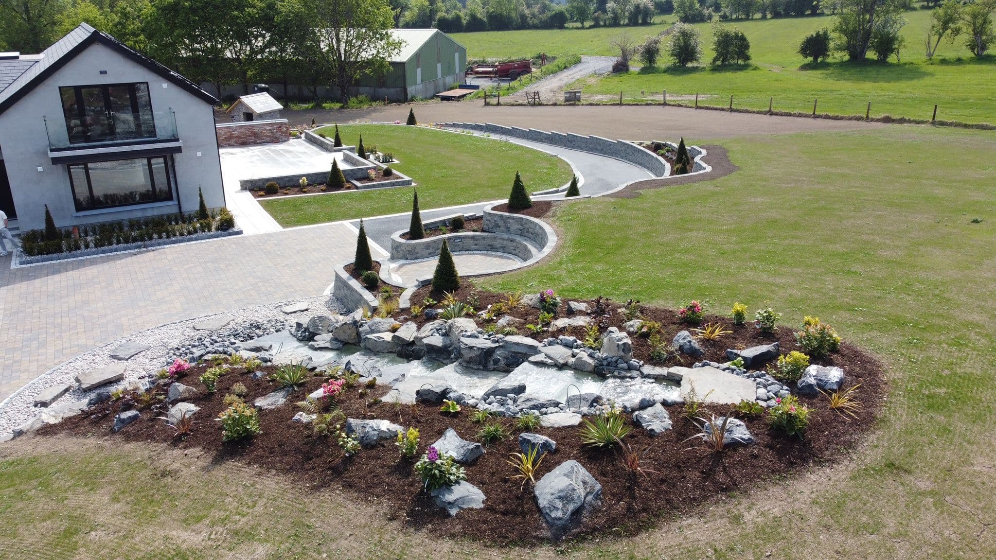 Aerial view of the finished house, granite paving, waterfall bed and lawns in Collinstown, Westmeath