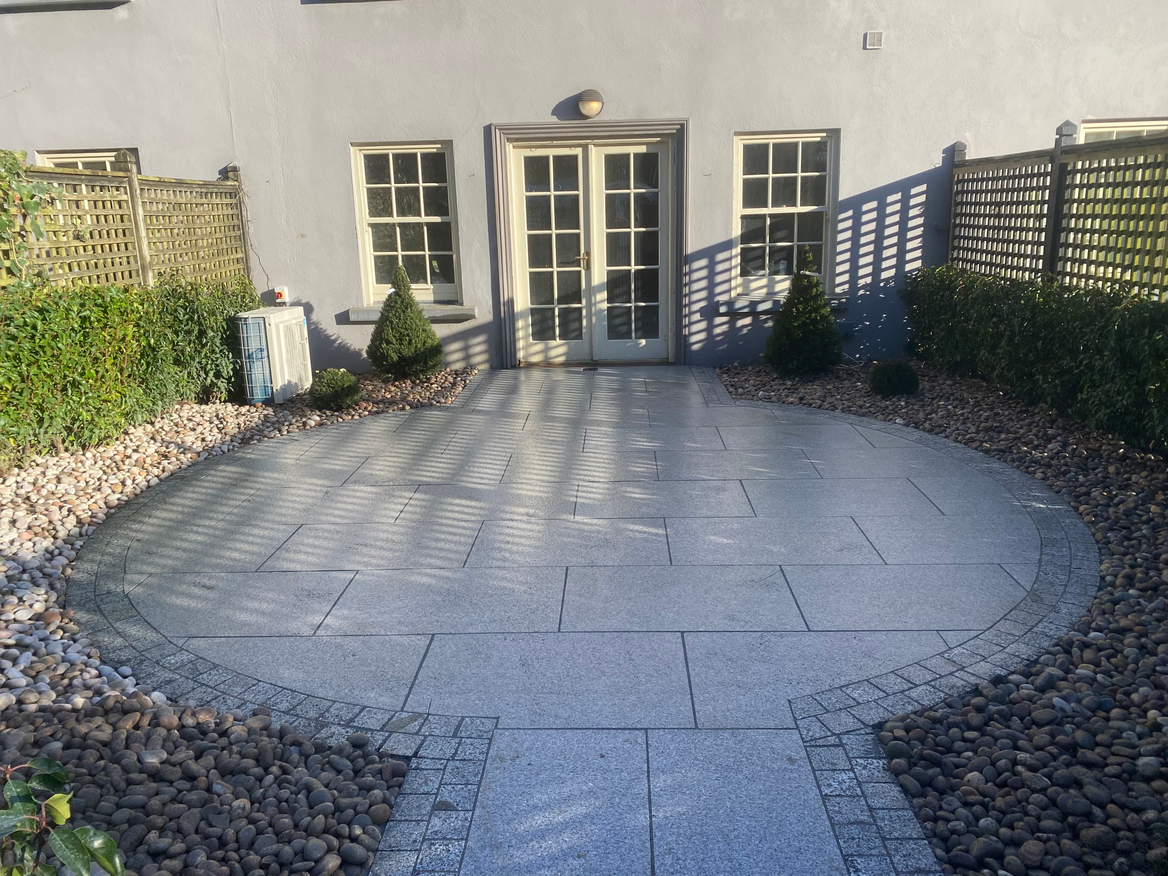 Circular granite patio surrounded by planting